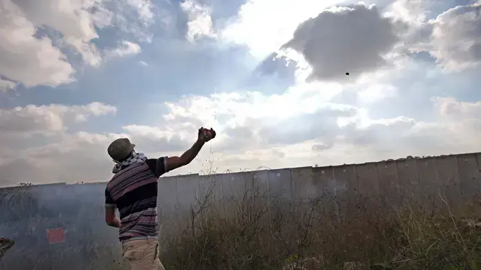 צעיר פלסטיני משליך אבן בזמן הפגנה סמוך לניעלין צעיר פלסטיני משליך אבן בזמן הפגנה סמוך לניעלין